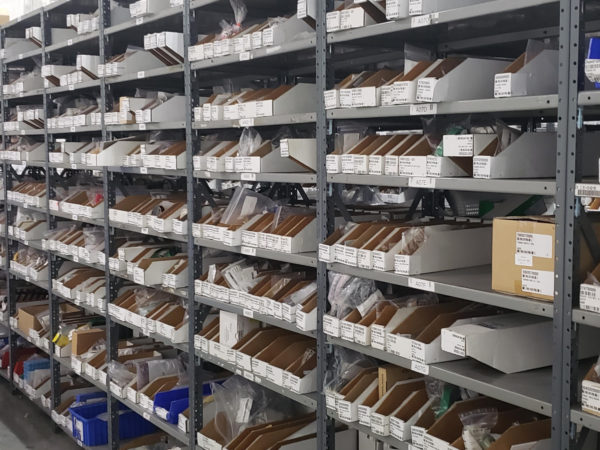 Metal shelving filled bins and boxes.