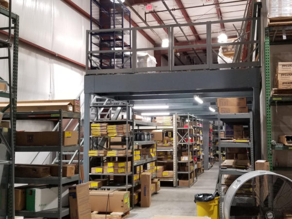 Standing on the ground looking towards a mezzanine with products with shelving and products below.