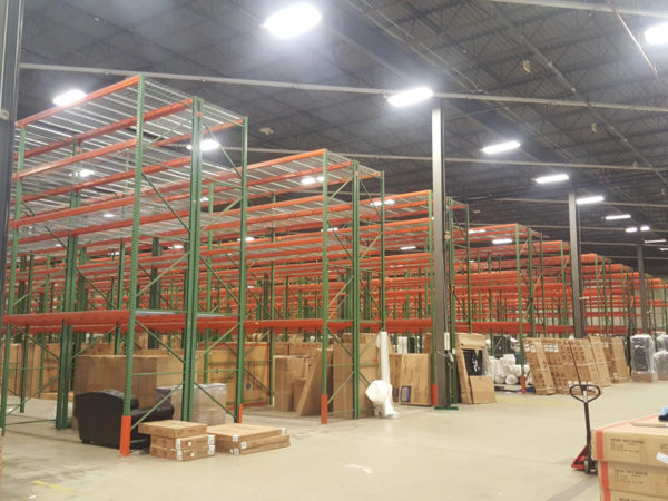 Pallet rack with wire deck in a warehouse with product around it ready to be loaded.