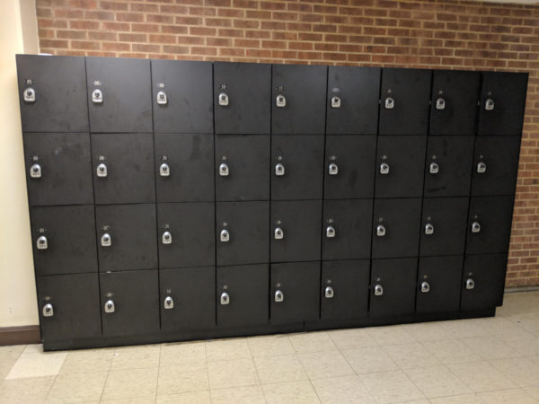 Four-tier phenolic lockers in a hallway, with a black finish.