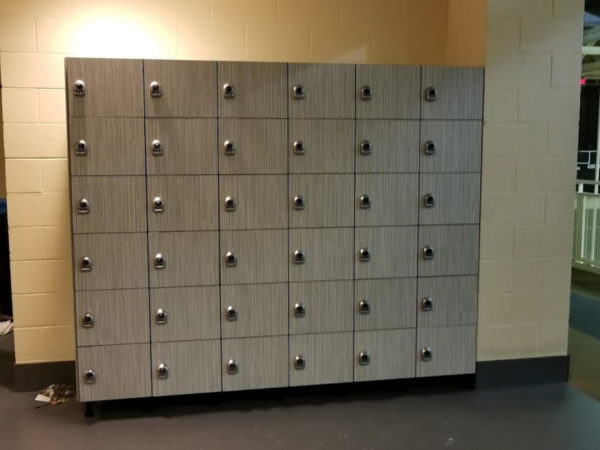 Six-tier phenolic lockers in a hallway, with a gray finish.