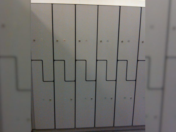 Plastic laminate z-lockers in a locker room, with a gray finish.