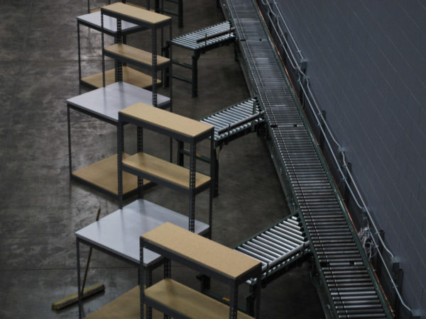 Rivet shelving in an economical packing bench setup, consisting of the packing bench itself and a conveyor belt.