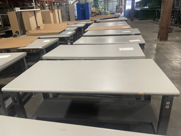 Multiple used workbenches lined up, assorted sizes and conditions