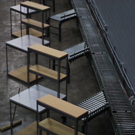 Rivet shelving in an economical packing bench setup, consisting of the packing bench itself and a conveyor belt.